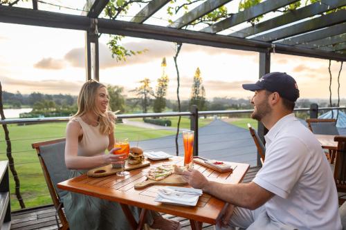 a man and woman sitting at a table on the patio at Devonvale Golf & Wine Estate in Stellenbosch