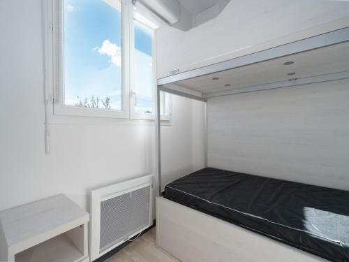 une petite chambre avec un lit et une fenêtre dans l'établissement La Dune 28 - Villa 3P6, à Sérignan