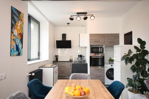 une cuisine avec une table avec un bol de fruits dessus dans l'établissement Votre appartement à Chalmazel, à Chalmazel