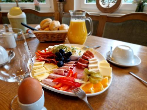 a plate of cheese and fruit on a table at Reiterhof Schmidt, Gaststätte & Pension in Golk