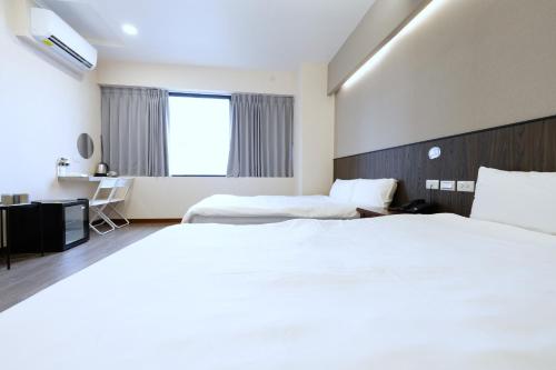 a hotel room with two beds and a window at 可青大飯店Grand Ke-Cing Hotel in Yilan City