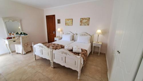a bedroom with two white beds and a mirror at Hotel Astron Princess in Karpathos Town