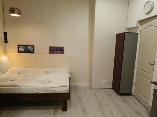 a small bedroom with a bed and a clock on the wall at Cluj Center 3 in Cluj-Napoca