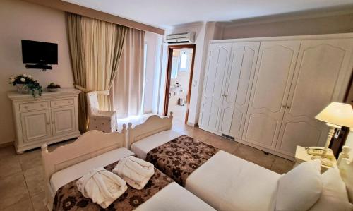a room with a bed and a couch and a tv at Hotel Astron Princess in Karpathos Town