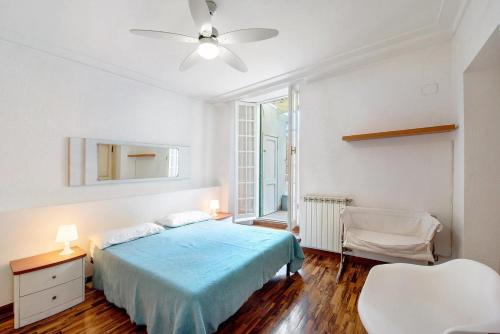 a bedroom with a bed and a ceiling fan at Capitan Romeo Apartment in Arenzano