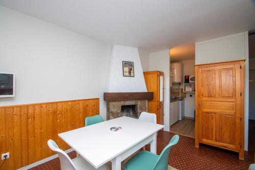une salle à manger avec une table et une cheminée dans l'établissement L'Evasion des Sommets - Studio pieds des pistes, à Saint-Lary-Soulan