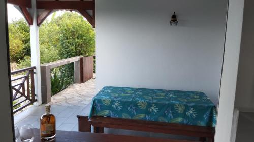 a room with a bed and a table and a window at "Le champs" des oiseaux in Anse-Bertrand