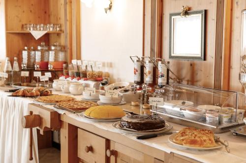 a buffet with many different types of food on a table at Hotel Al Bivio - Pizzeria, Pool & Sauna in Imer