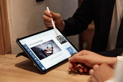 a person holding a wooden stick in front of a tablet at Hotel Al Bivio - Pizzeria, Pool & Sauna in Imer