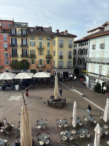a group of tables and umbrellas in a courtyard with buildings at Casa Caterina in Intra
