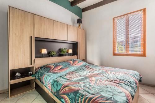 une chambre avec un grand lit avec une tête de lit dans l'établissement Les Sablons, à Leucate