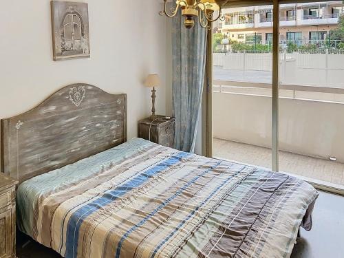 une chambre avec un lit et une grande fenêtre dans l'établissement Bel appartement à 2 pas des plages 151L DEBL, à Cannes