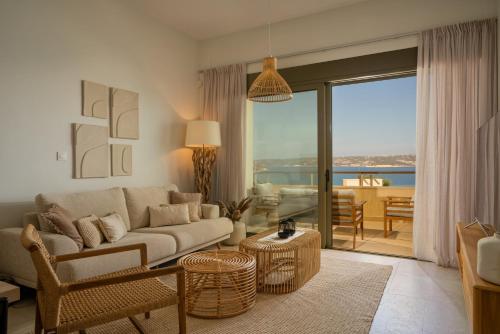 a living room with a couch and a view of the ocean at Panorama Seaview Village at Kalyves in Kalyves