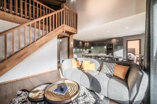un salon avec un canapé et un escalier dans l'établissement Jeanette 6, à Morzine
