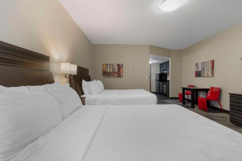 a hotel room with two beds and a desk at Best Western Plus Airport Inn & Suites in Saskatoon
