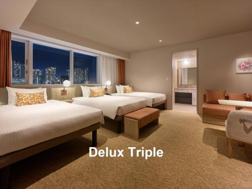 東京にある三井ガーデンホテル銀座築地のベッド2台とソファがあるホテルの部屋
