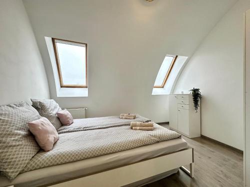 a bedroom with a bed with two windows at FREE PARKING - Stargate Budapest in Budapest