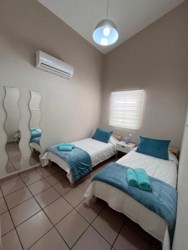 two beds in a room with blue pillows at Doral Paradise Gran Canaria in Maspalomas