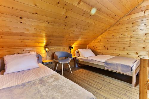 a room with two beds in a wooden cabin at Elite Rooms Kolasin in Kolašin