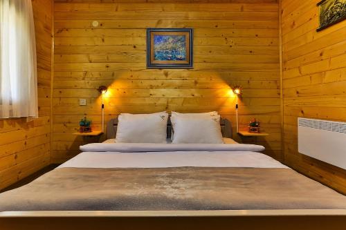 a bedroom with two beds in a wooden wall at Elite Rooms Kolasin in Kolašin