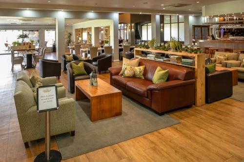 a lobby with couches and tables and a bar at Devonvale Golf & Wine Estate in Stellenbosch