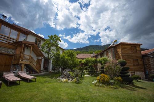 a yard with benches and a house with mountains in the background at Villa Dihovo in Bitola