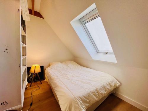 une petite chambre avec un lit et une fenêtre dans l'établissement Appartement rénové 3P - Piscine & Tennis, proche plage - FR-1-478-302, à Quiberon