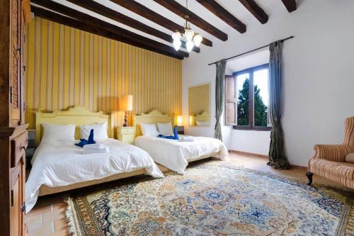 a bedroom with two beds and a large rug at Casa Histórica con Piscina Sauna y Jacuzzi in Lloseta