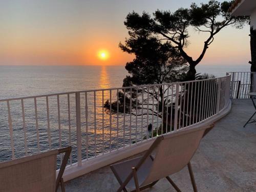 a view of the ocean from a balcony with a sunset at Maripins Villa con jacuzzi y vistas únicas al mar in Banyalbufar
