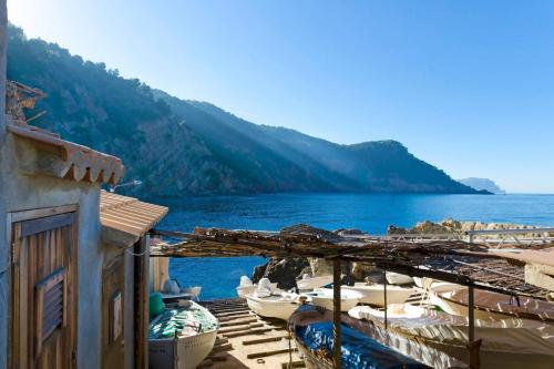 a group of boats parked next to a body of water at Maripins Villa con jacuzzi y vistas únicas al mar in Banyalbufar