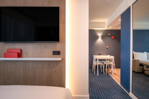 a hotel room with a bed and a table with chairs at Holiday Inn Express & Suites Ghent by IHG in Ghent
