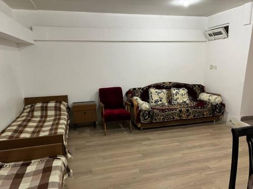 a room with a bed and a couch and a chair at Hostel EURO in Baku