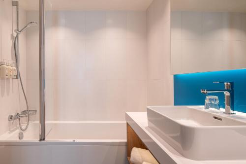 a white bathroom with a sink and a shower at Holiday Inn Express & Suites Ghent by IHG in Ghent