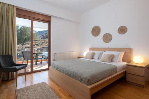 Un dormitorio con una cama grande y un balcón. en Vitzi Vista Villa, en Rodas