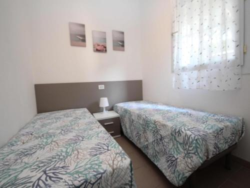 a bedroom with two beds and a window at Modern flat located in Rosolina near the sea in Rosolina Mare