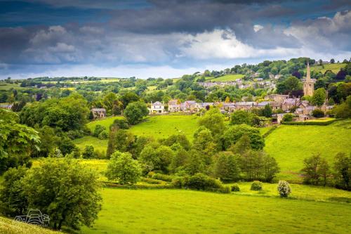 a green field with trees and houses on a hill at The Old Poets' Corner in Chesterfield