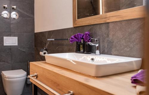 a bathroom with a white sink and a toilet at FOR MOMENTS Apartments & Spa in Roßhaupten