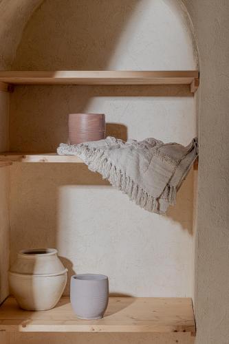 a wooden shelf with bowls and bowls on it at Serab Residencia, Boutique Hotel & Resort in Al Kaslīk
