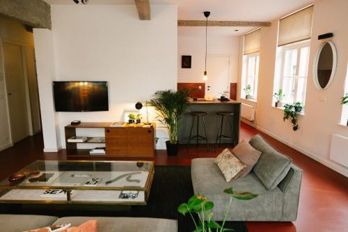 un soggiorno con un divano e un tavolo di Aplace Antwerp - marvellous flats & hotel rooms - Leeuwenstraat 20 ad Anversa