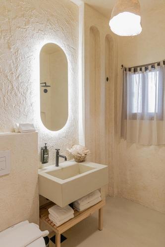 a white bathroom with a sink and a mirror at Serab Residencia, Boutique Hotel & Resort in Al Kaslīk