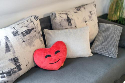 a red heart pillow sitting on a couch with pillows at Haus Ursula in Ettenheim