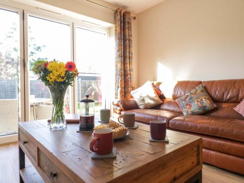 a living room with a couch and a wooden coffee table at Farmer's Rest in Ely