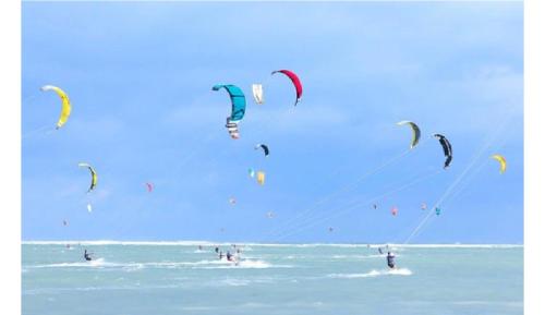 a group of people flying kites in the ocean at Dan's house in Kinh Dinh