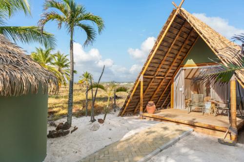 a small hut on the beach with palm trees at Cabanas Blue in Mata de Sao Joao
