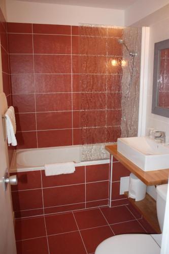 a bathroom with a red tiled shower and a sink at Logis Latitude Ouest Hôtel Restaurant & Spa in Locronan