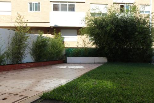 a garden with a sidewalk in front of a building at Oportocean Hostel in Matosinhos