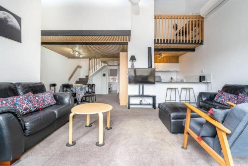 a living room with couches and a table and a kitchen at 3BR Loft Apt 1min to Kingston Foreshore - Hosted by Canstay in Kingston 