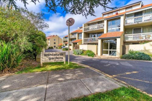 a sign in front of a building with a courtyard garden at 3BR Loft Apt 1min to Kingston Foreshore - Hosted by Canstay in Kingston 