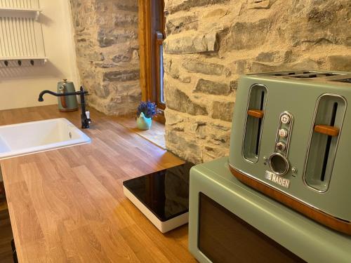 un four grille-pain vert installé au-dessus d'un comptoir dans l'établissement Yairbrig Cottage, à Galashiels