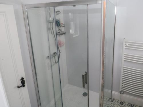 a shower with a glass door in a bathroom at The English School, Flat 2 in Dartmouth